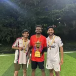 Three students posing proudly with a football trophy after winning a match, showcasing student achievements at the best digital marketing institute in Calicut.