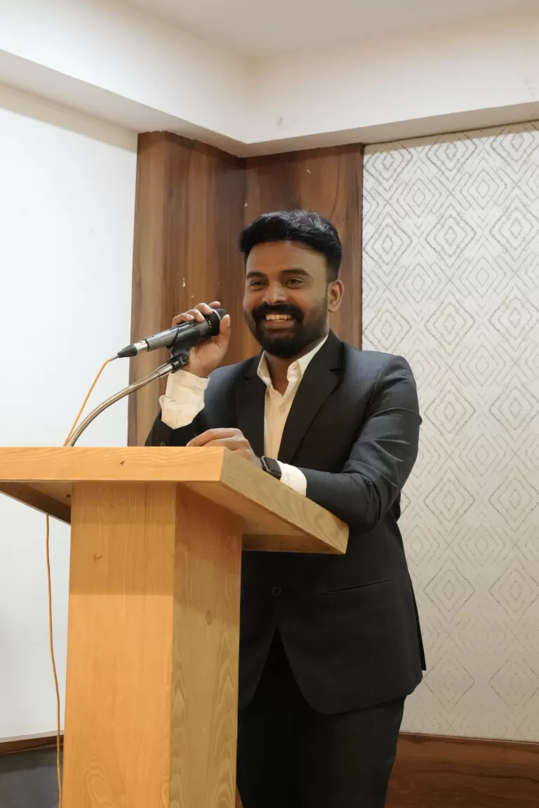 Founder and CEO of the best digital marketing academy in Calicut speaking confidently at the third anniversary event with a welcoming smile.